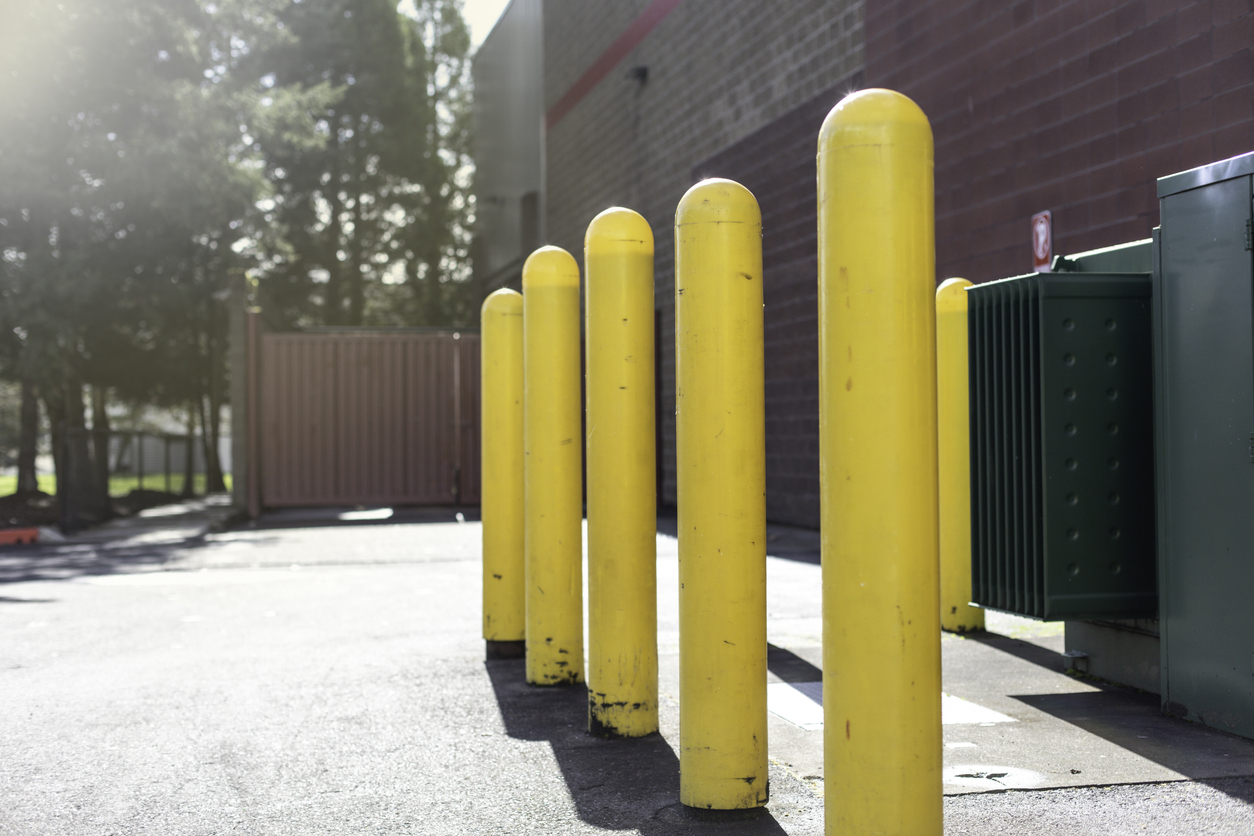 Yellow safety bollards protecting electrical equipment.