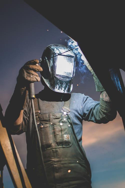 Professional mobile welder performing stick welding on structural steel at a construction site in Newport News, Virginia.